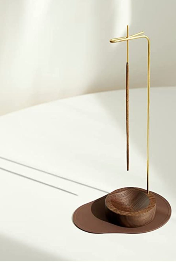 a wooden bowl with a cross on it and a long stick sticking out of it