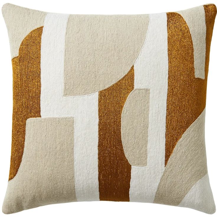 a brown and white pillow with an abstract design on the front, along with two different colors