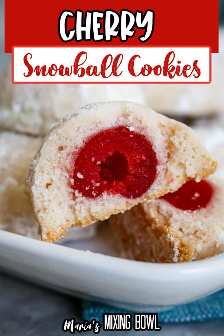 a white plate topped with snowball cookies covered in icing and strawberry jam next to a bowl of powdered sugar