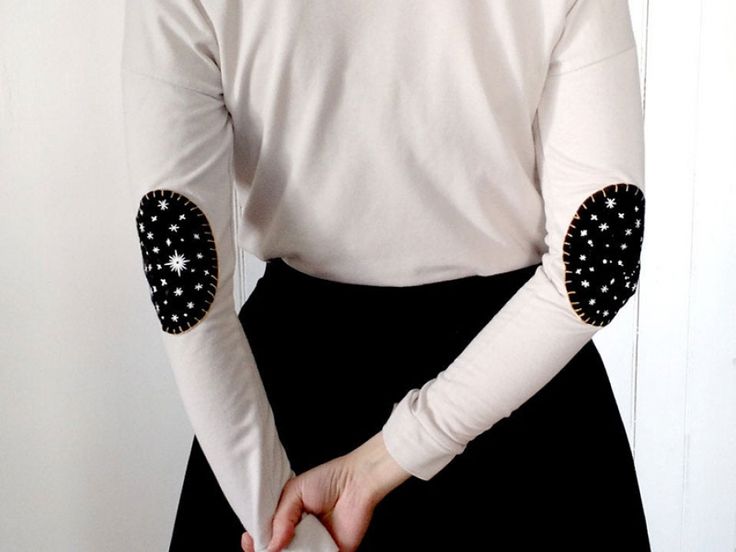 a woman in a white shirt with black polka dots on her arm and elbow sleeves