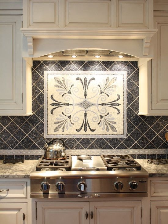 an ornate tile backsplash in a kitchen with white cabinets and stainless steel appliances