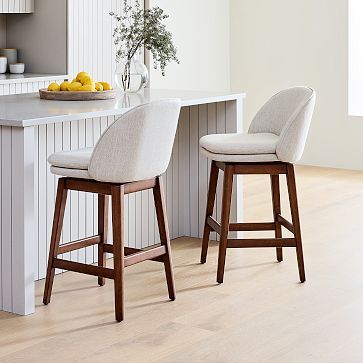 two stools in front of a kitchen island with lemons on the counter top