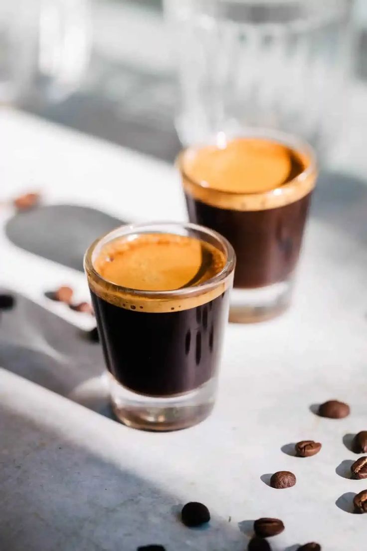 two cups of coffee sitting on top of a counter