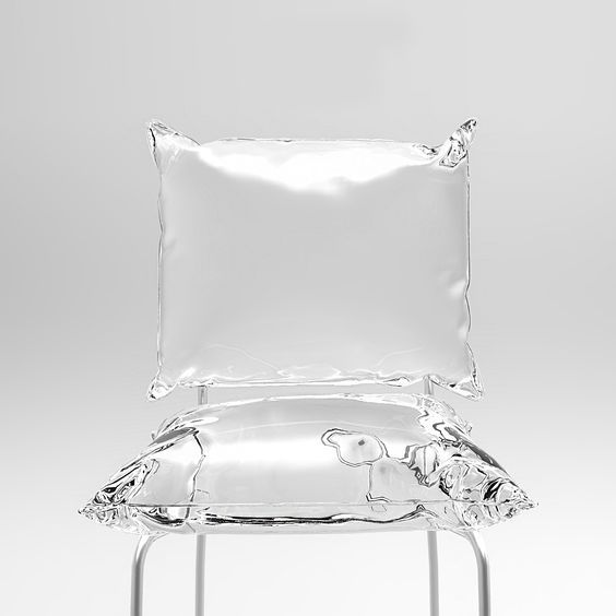 a glass chair with a pillow on top of it