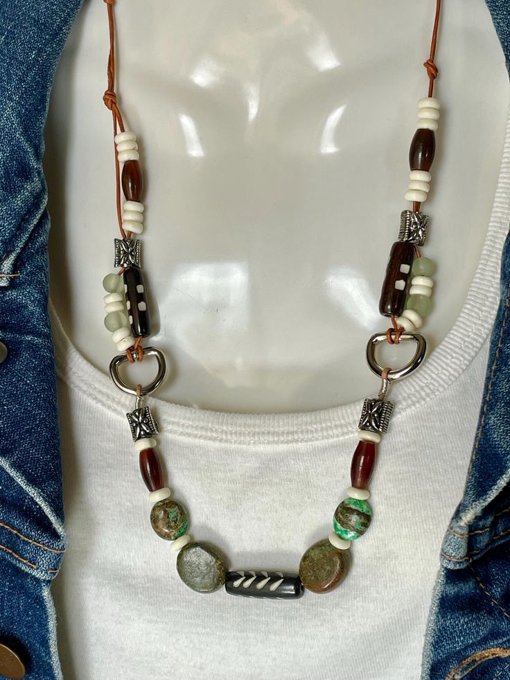 Unique necklace of two Genuine brown and green Turquoise stones, Bone, Aventurine, Silver Alloy and carved glass beads on two strands of 1mm tan leather cord with toggle to close. Length of necklace  is 20". No lead or nickel used. Please use the Last On, First Off approach. Stones discolor with lotions, perfumes, hairspray, sweat, chlorine, even some soaps, and will break if dropped. Adjustable Bohemian Turquoise Necklace With Large Beads, Bohemian Turquoise Necklace With Large Adjustable Beads, Adjustable Green Turquoise Necklace For Festival, Bohemian Turquoise Necklace With Large Beads, Earthy Turquoise Necklaces For Festivals, Earthy Green Necklace For Festivals, Earthy Green Necklace For Festival, Southwestern Adjustable Necklaces For Healing, Earthy Green Jewelry For Festivals