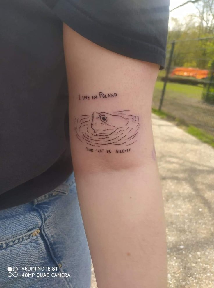 a person with a tattoo on their arm that says i live in poland the water is silent