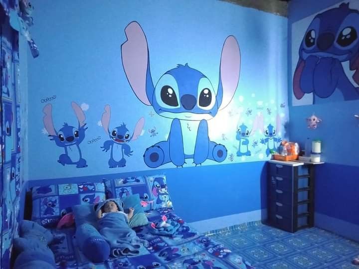 a child's bedroom decorated in blue and pink with cartoon characters on the walls