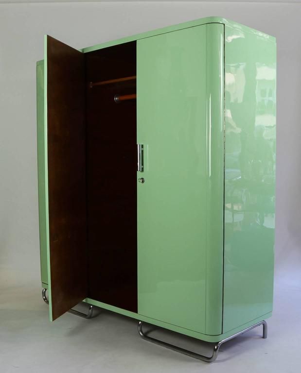 a green and brown cabinet sitting on top of a white floor