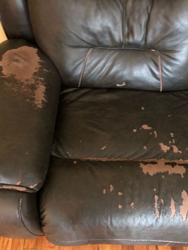 a black leather recliner with brown stains on it