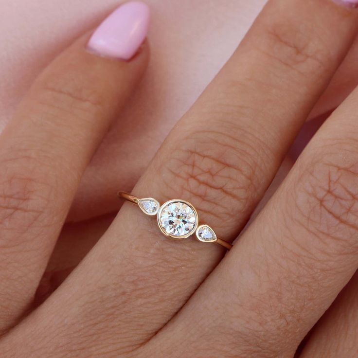 a woman's hand with a diamond ring on it