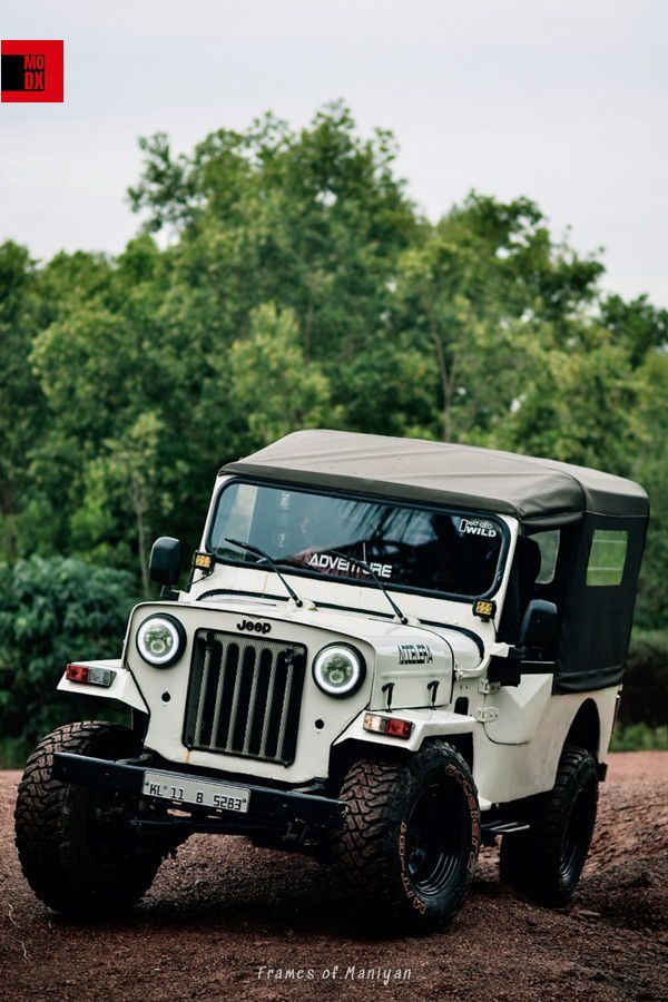 a white jeep driving down a dirt road