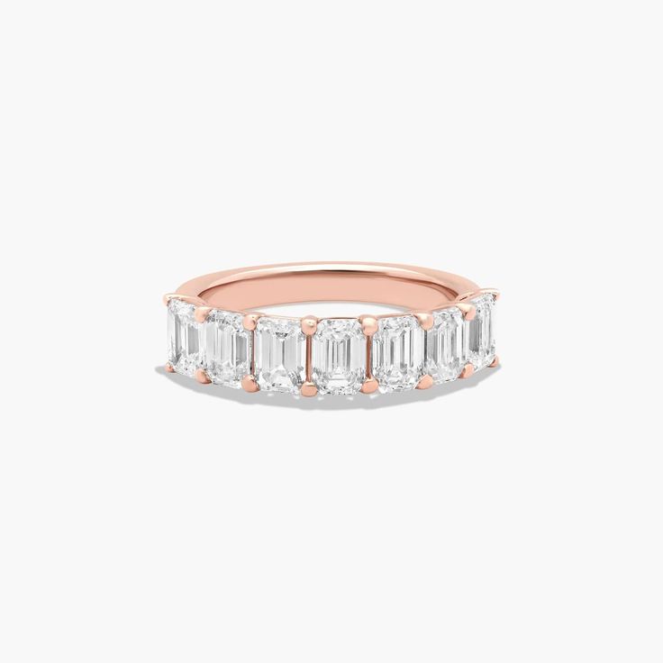 a rose gold ring with three baguettes on the side and two diamonds in the middle