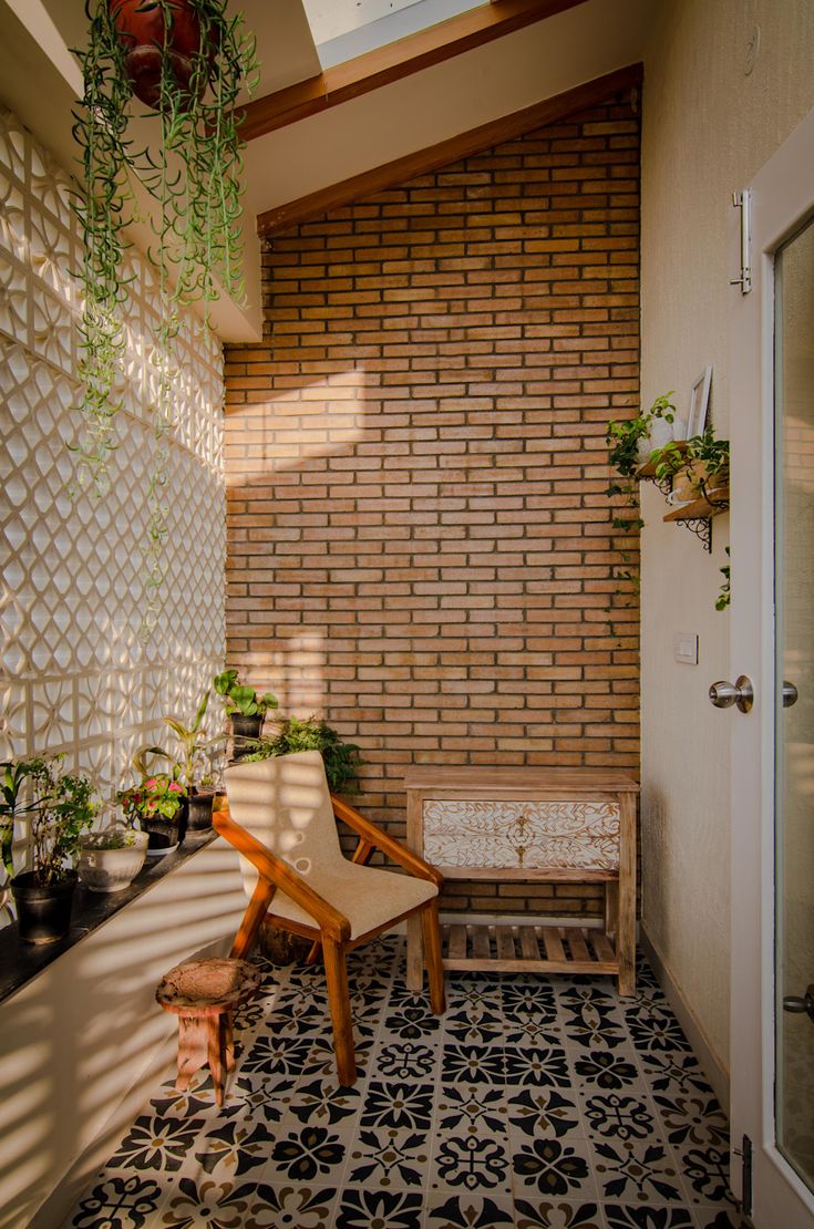 a wooden chair sitting in front of a window next to a planter filled with potted plants