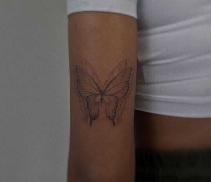 a woman's arm with a butterfly tattoo on the left side of her body