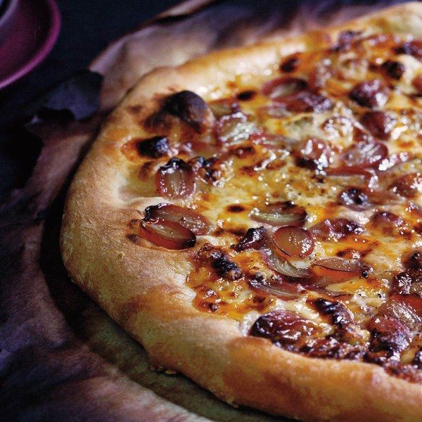 a pizza sitting on top of a wooden cutting board