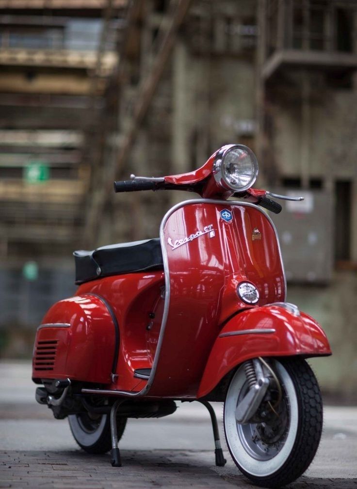 a red scooter is parked on the street