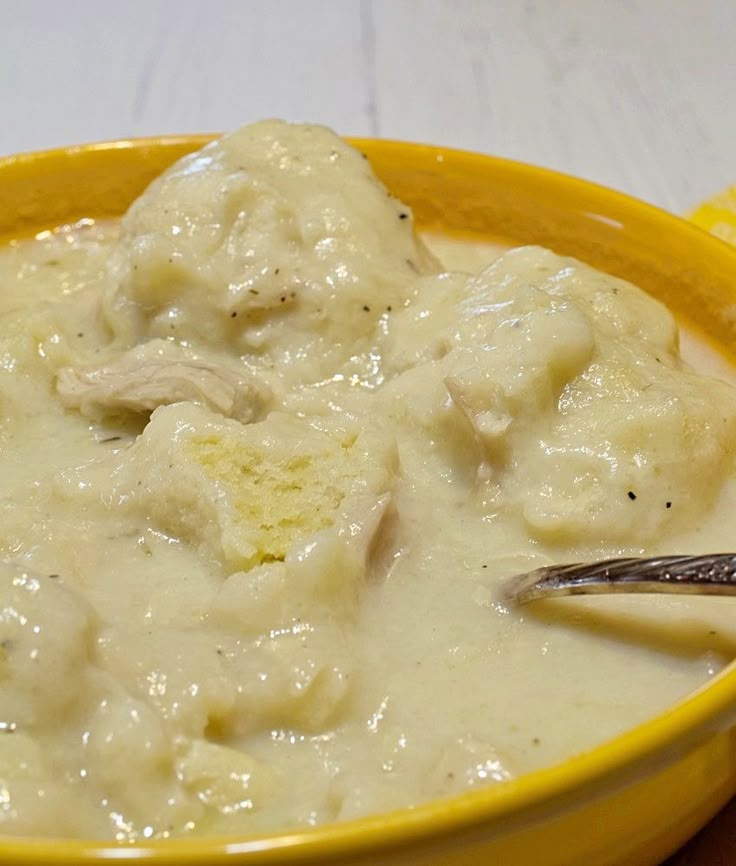 a yellow bowl filled with meat and gravy