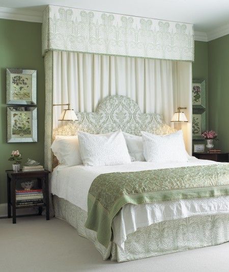 a bedroom with green walls, white bedding and two lamps on either side of the bed