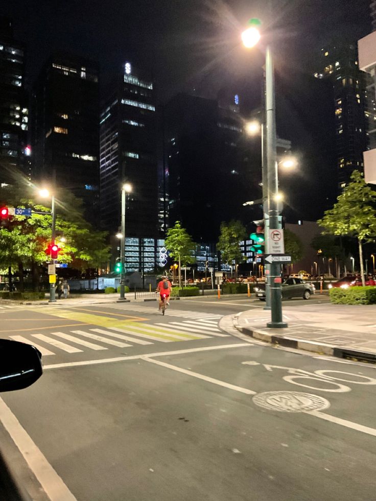 a city street at night with tall buildings