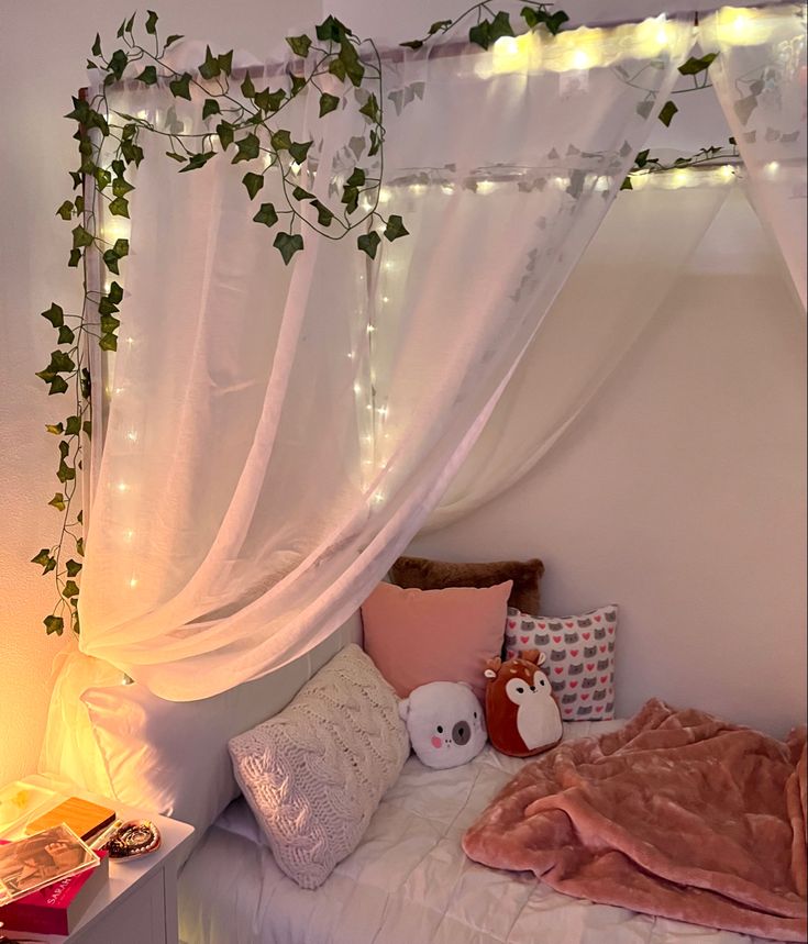 a bed with white curtains and pink pillows