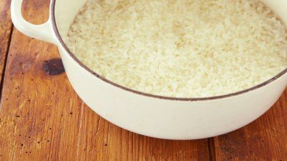 a bowl filled with rice sitting on top of a wooden table