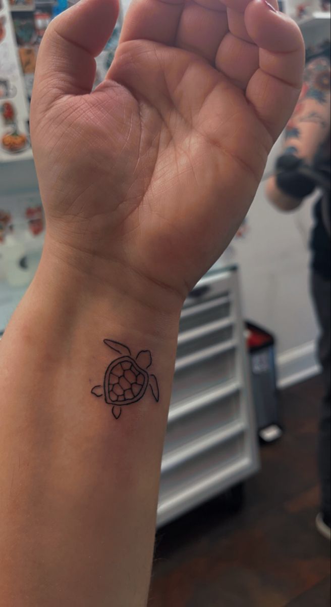 a small turtle tattoo on the wrist