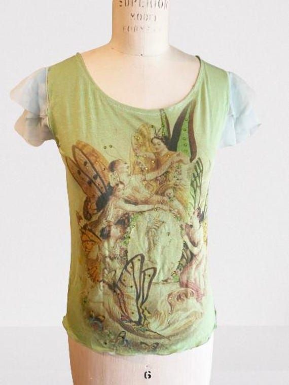 Handmade Y2K-Inspired, Tank Top - Unique Original Print - Size SMALL - Women's 4/6 Cute fitted top in light green with nature loving fairy print. The top is printed on the front and back, with small light green crystals.  FLAT GARMENT MEASUREMENTS: CHEST: Armpit to Armpit:  16.5 inches -  41.91 centimeters ARM OPENING:  6 inches - 15.24 centimeters FRONT LENGTH:  High Shoulder to hem:  21 inches - 53.34 centimeters BACK LENGTH: Back center neck to hem: 20 inches - 50.8 centimeters ------------------------------------------------------ FABRIC CONTENT:  Body is 100% rayon jersey fabric  (prewashed: will not shrink | color will not run) Sleeves are 100% silk with raw edges CARE: Hand Wash & Air Dry ------------------------------------------------------ Add a blast of early 2000s nostalgia to 2000 Tank Top, Sewn Tops, Light Green Crystals, Original Y2k, Butterfly Print Dress, Green Fairy, 2000s Nostalgia, Cropped Tube Top, Fitted Top