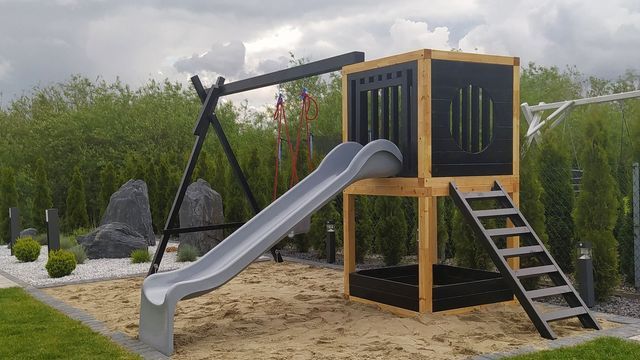 a playground with a slide and climbing frame