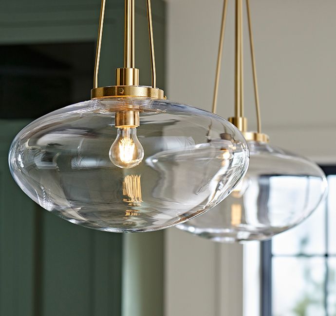 three clear glass globe lights hanging from a ceiling fixture in a room with green walls