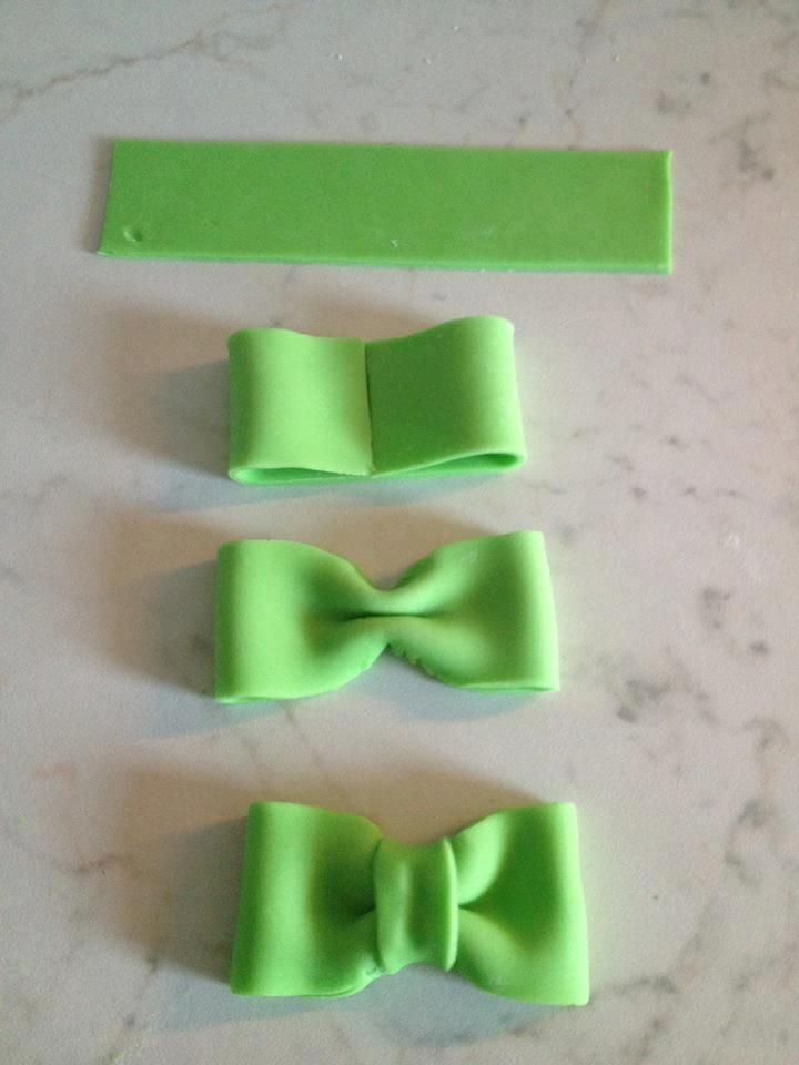 three pieces of green paper with bows on them sitting on a counter top next to each other