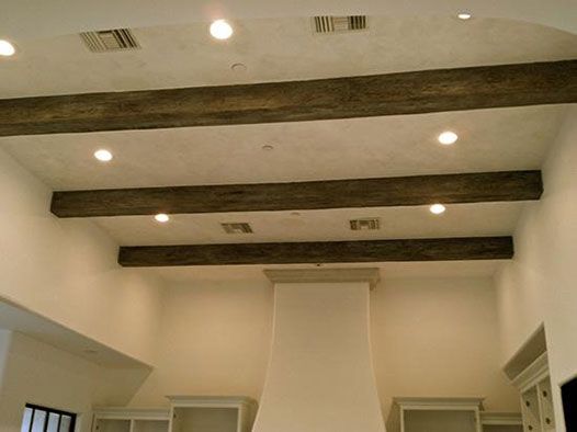 an empty kitchen with white cabinets and wood beams on the ceiling is pictured in this image