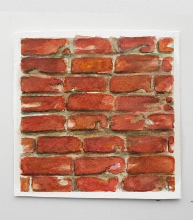 a piece of paper that has been made to look like a brick wall with red paint on it