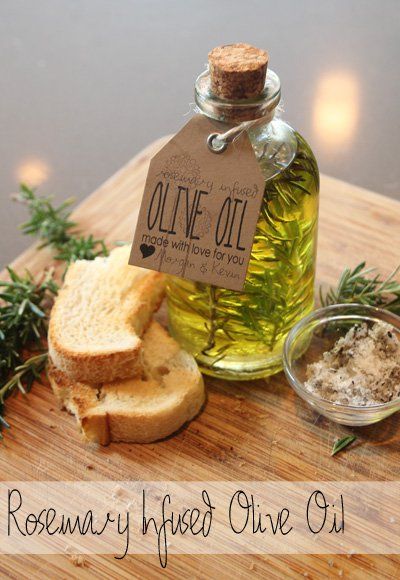 a bottle of olive oil next to bread and herbs