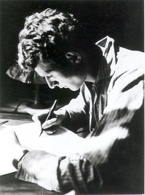 black and white photograph of a young man writing