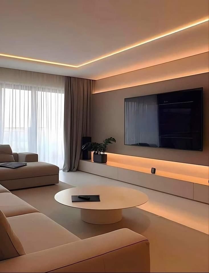 a living room with couches and a flat screen tv mounted on the wall above it