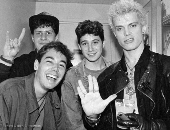 four young men posing for the camera with their fingers in the air and one holding up two peace signs