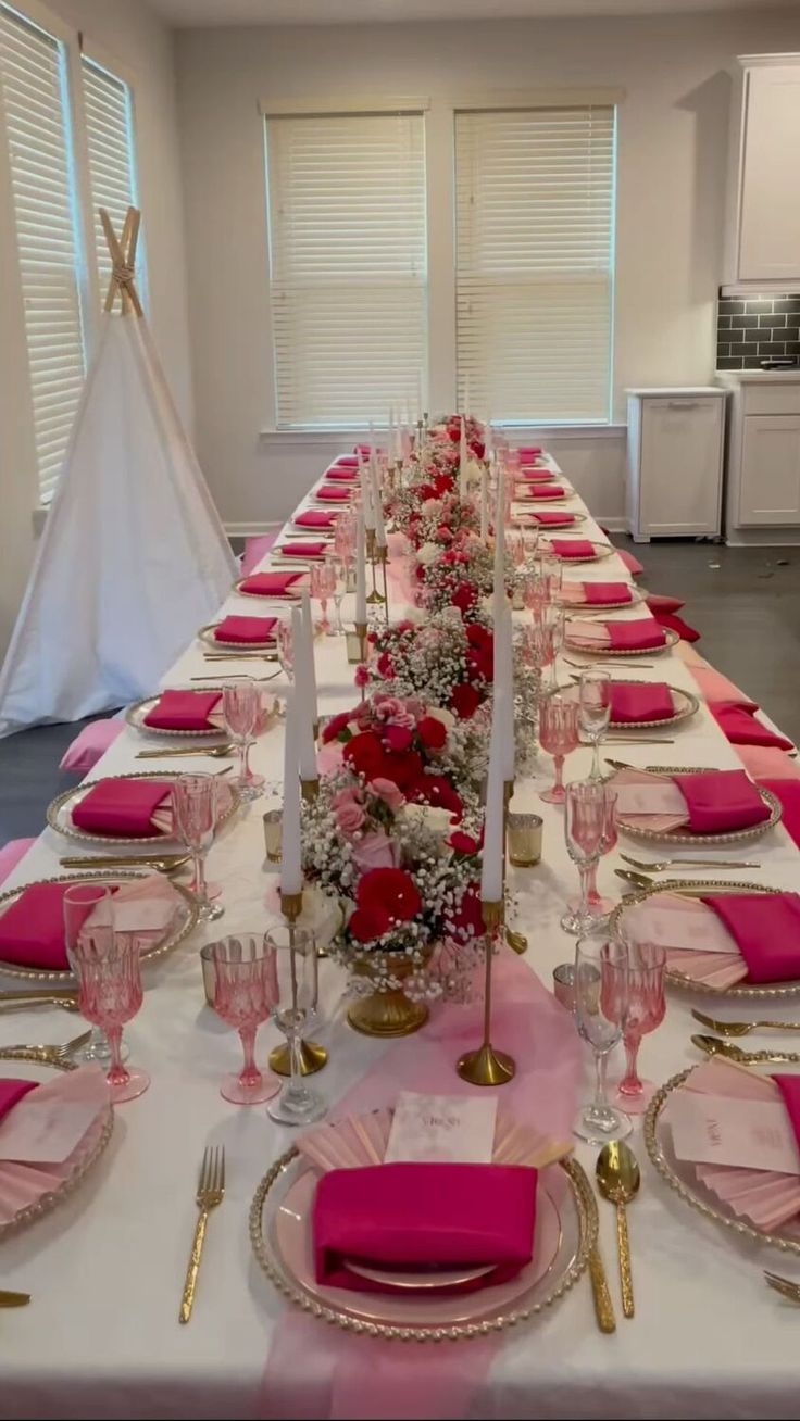 the table is set with pink and gold place settings