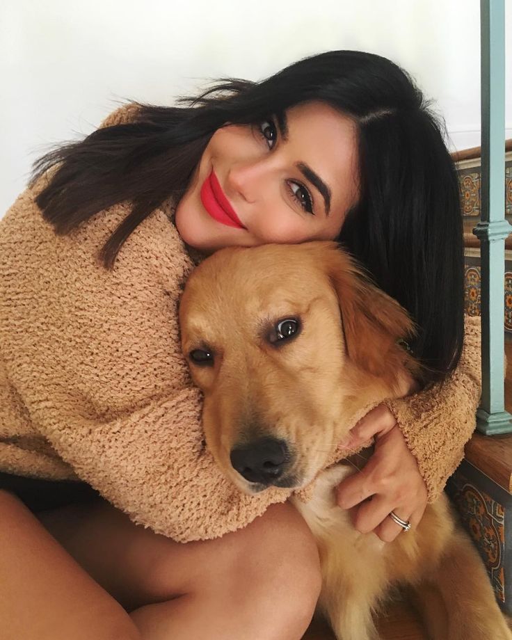 a woman is hugging her dog on the stairs