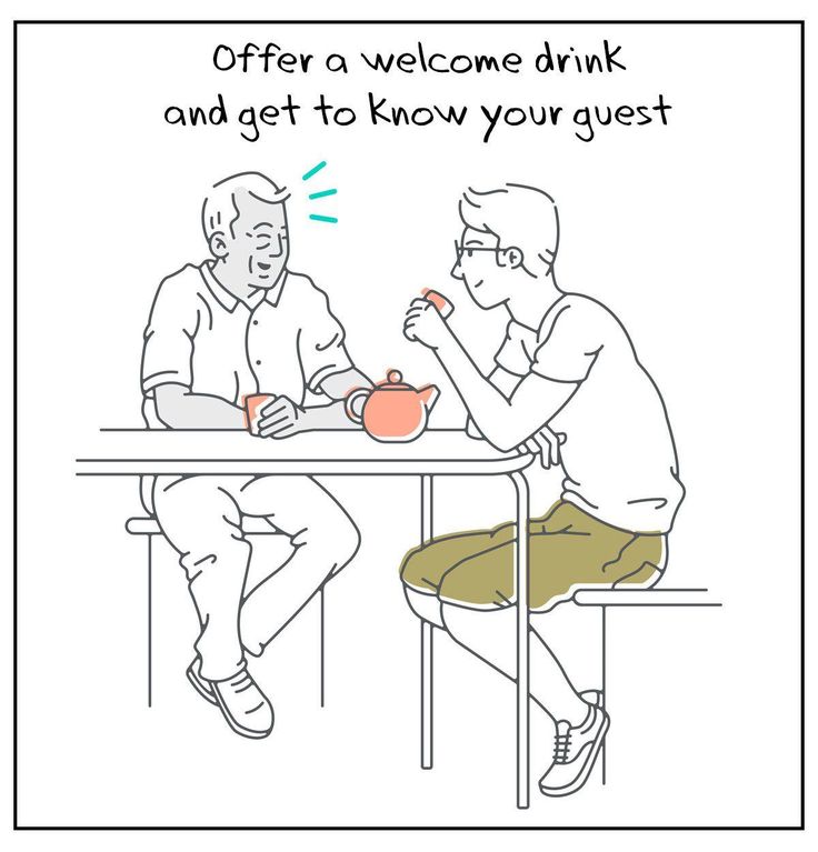 two people sitting at a table having tea and one is holding a cup with the other hand