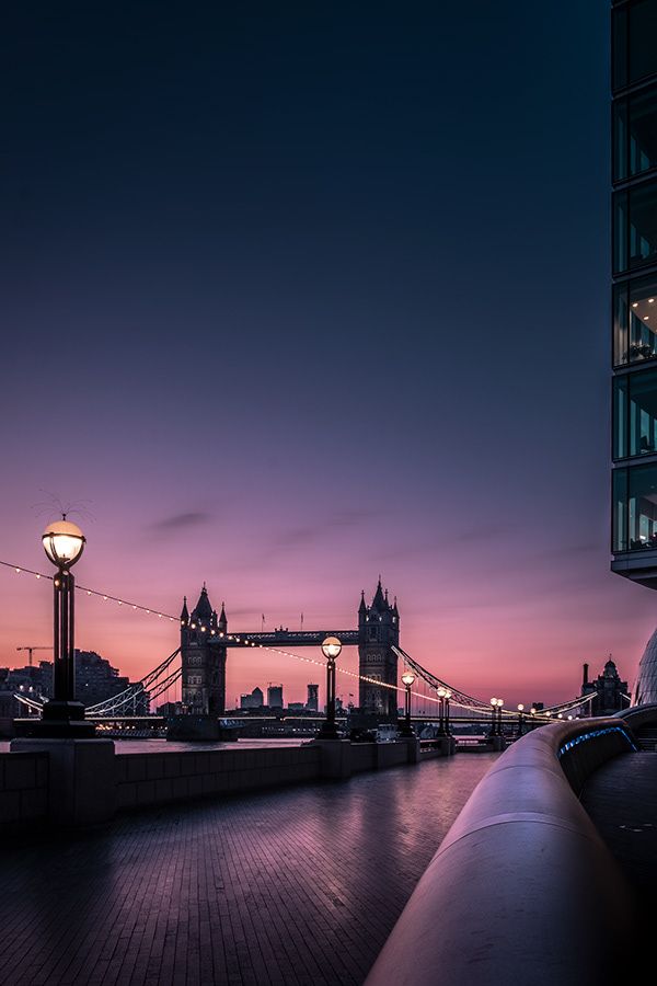 the tower bridge is lit up at night