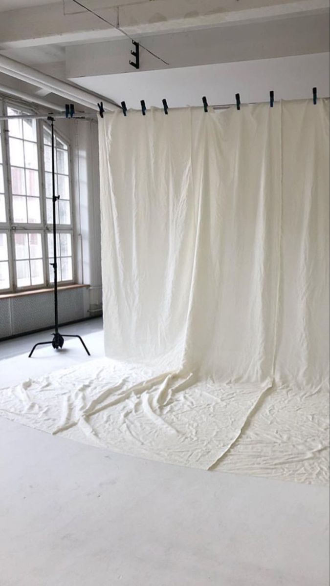 an empty room with a white curtain hanging from the ceiling