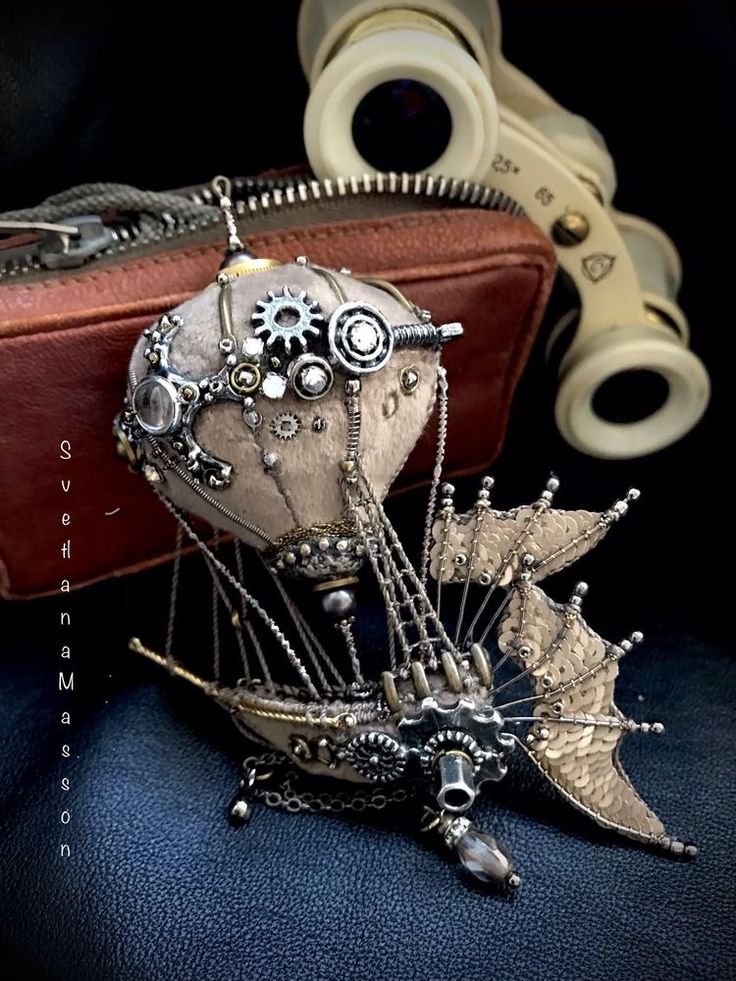 a pair of scissors sitting on top of a table next to a piece of jewelry