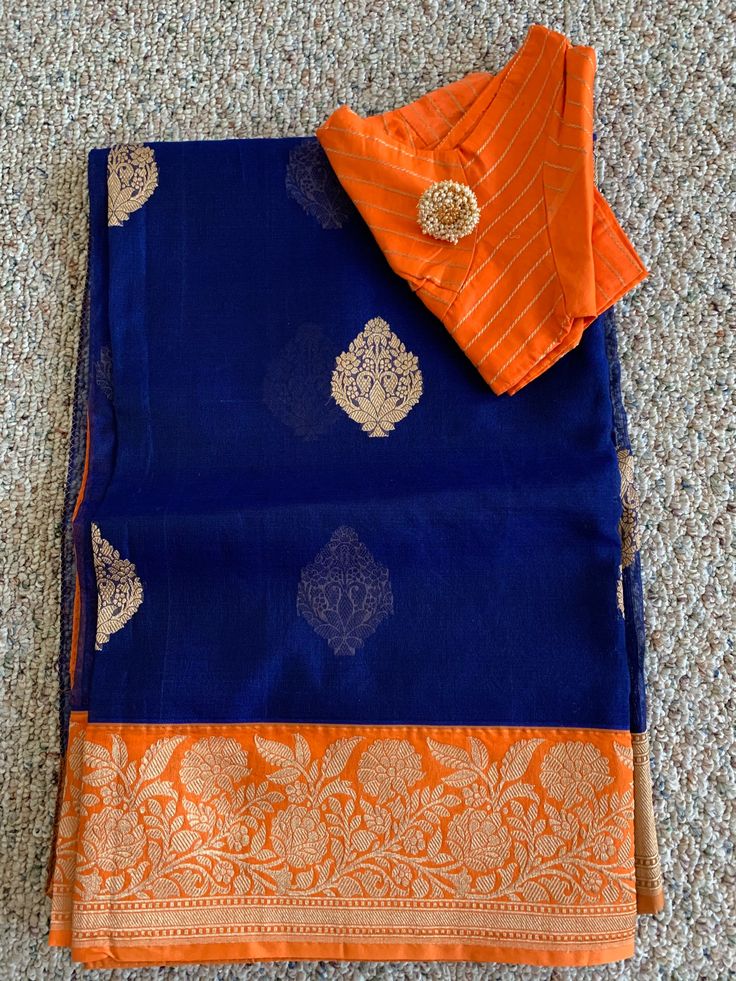 Item - Blue and Orange Border Benarasi Silk Saree. Comes with fall, pico and stitched matching blouse in size 38. There is space on both sides of the blouse for alterations.  Color - Blue and Orange. Condition - New Please note - Based on lighting there could be slight variation in shade/hues and look of the product. Blue Blouse With Dupatta For Festive Occasions, Blue Dupatta Blouse For Eid, Blue Blouse With Dupatta For Eid, Designer Blue Cotton Silk Blouse Piece, Blue Silk Blouse With Dupatta, Designer Blue Salwar Kameez With Unstitched Blouse, Blue Salwar Kameez With Unstitched Blouse, Blue Cotton Silk Kurta With Pallu, Designer Blue Blouse For Eid