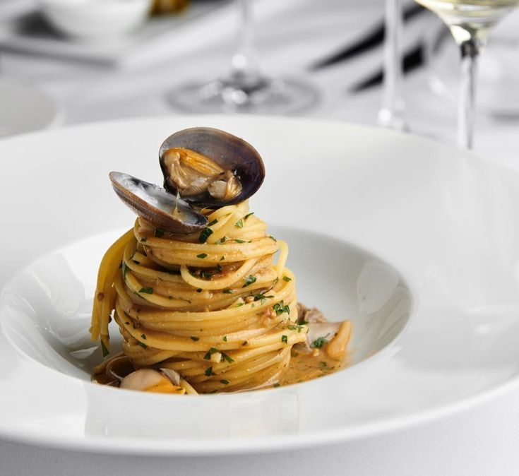 pasta with clams and sauce in a white bowl