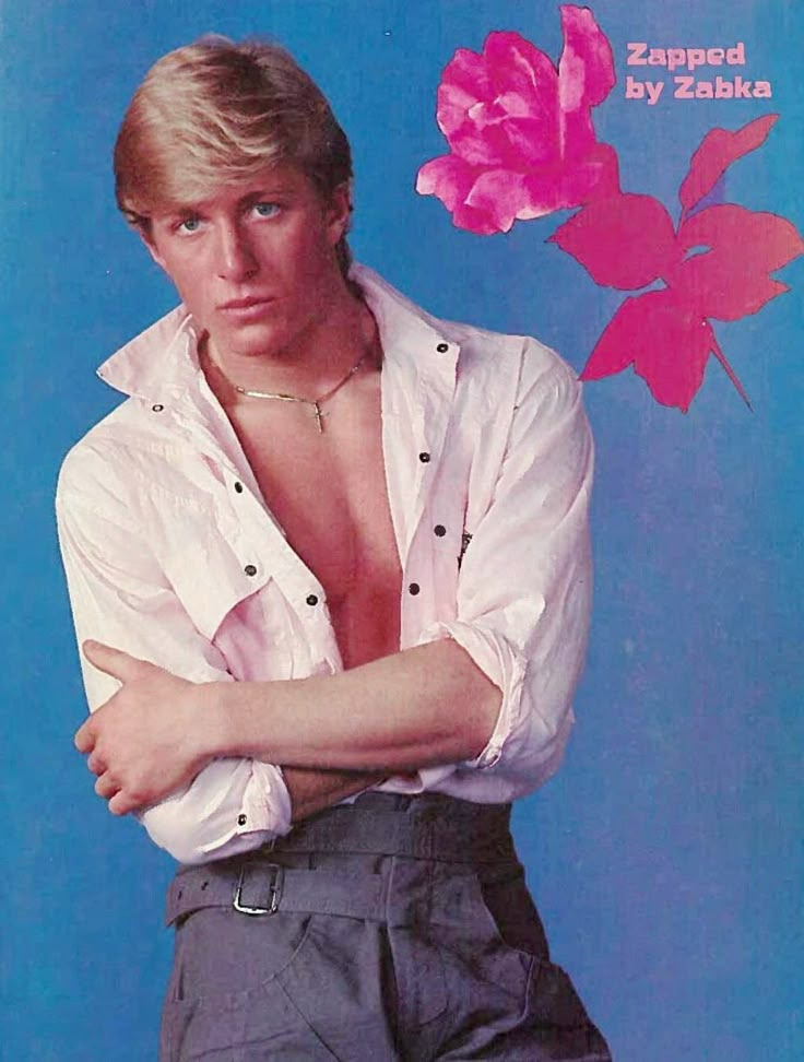 a man with his arms crossed sitting on a chair in front of a blue background