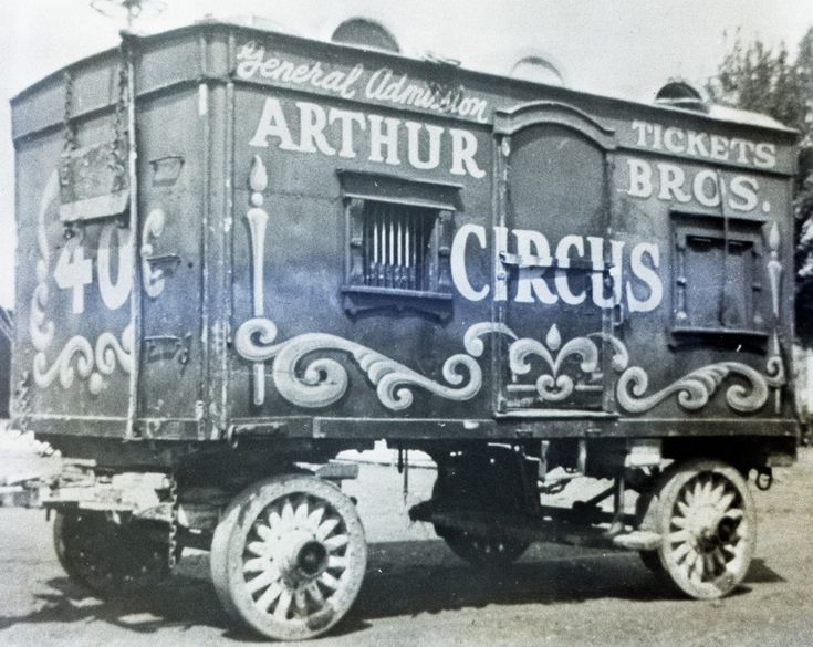 an old black and white photo of a circus train car with ornate lettering on the side