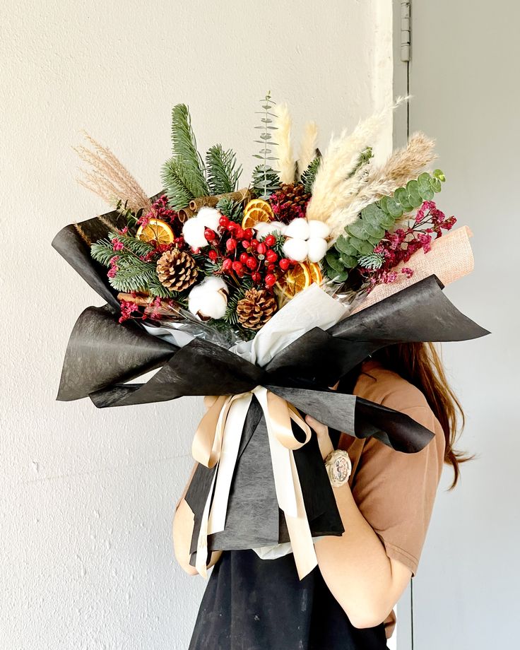 a woman holding a bouquet of flowers in her hands