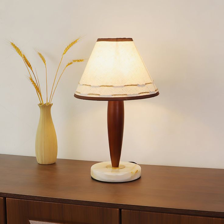 a table lamp sitting on top of a wooden dresser