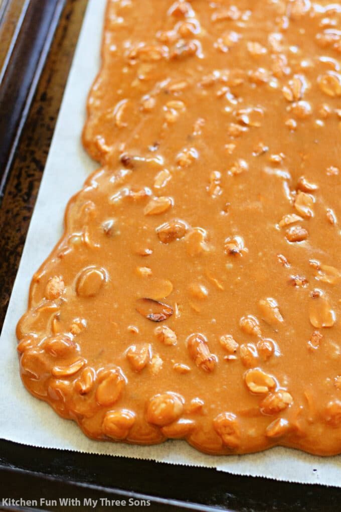 peanut butter and peanuts spread on top of a cookie sheet