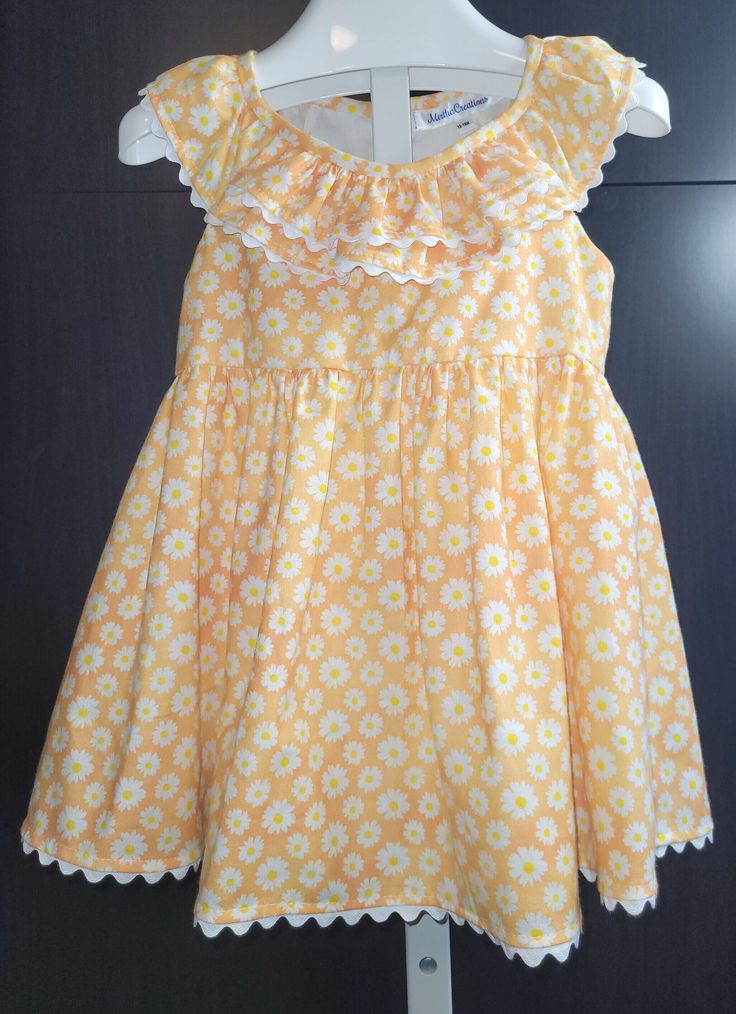 Natural shape, A-line, toddler dress in floral print (white daisies over yellow shades background), adorned with white rick rack for casual wear Cotton A-line Dress With Ruffles, Cute Cotton A-line Sundress, Cute A-line Cotton Sundress, Cute A-line Sundress For Garden Party, Yellow Ruffle Dress For Spring, Yellow Ruffled Dress For Spring, Spring Yellow Ruffled Dresses, White Summer Dresses With Scalloped Edges, White Summer Dress With Scalloped Edges